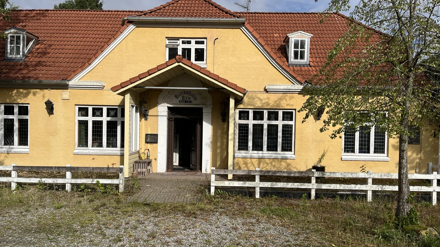 Den gule facade, træværket og indgangen til Rindsholm Kro